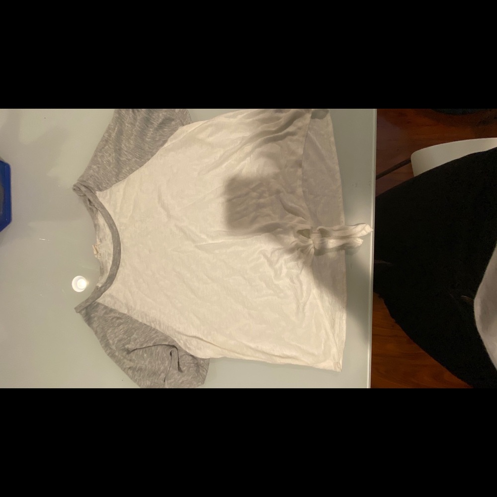 A grey and white shirt with a knot at the bottom.